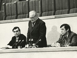 1990 m. kovo 11 d. rinkimų į XII šaukimo Letuvos TSR Aukščiausiąją Tarybą Respublikos rinkimų komisija vadovauja Aukščiausios Tarybos darbui. Stovi komisijos pirmininkas Juozas Bulavas, sėdi: iš kairės – komisijos sekretorius Viktoras Rinkevičius, iš dešinės – komisijos pirmininko pavaduotojas Vaclovas Litvinas. Nuotraukos autorius: nežinomas. Reginos ir Zigmo Vaišvilų asmeninis archyvas.
